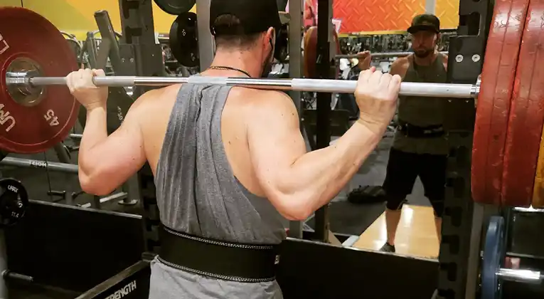 A man lifting the weight and wearing Element 26 Hybrid Leather Weightlifting Belt for support the body posture.